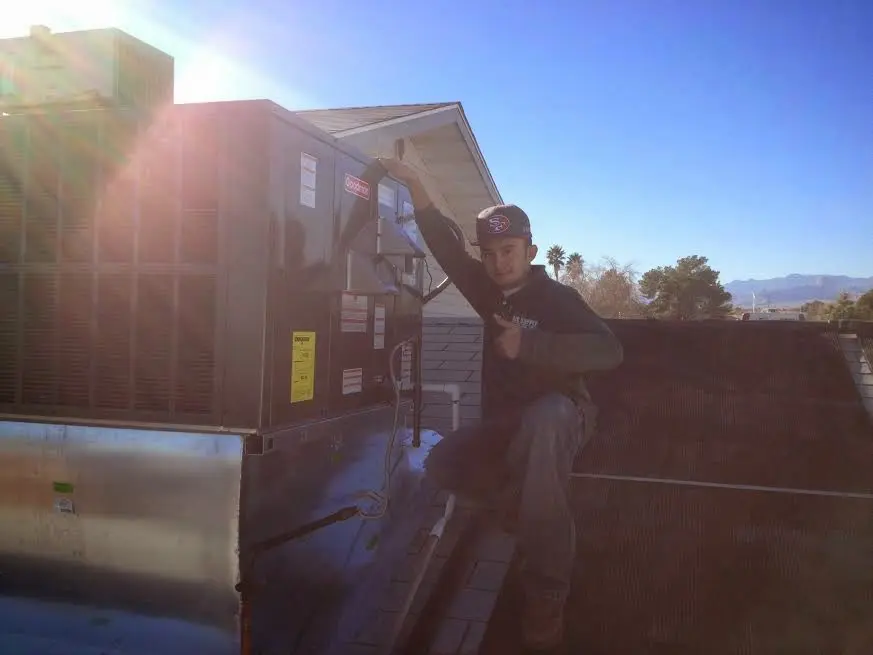 HVAC technician performing Heat Pump Repair on a rooftop unit in Fremont